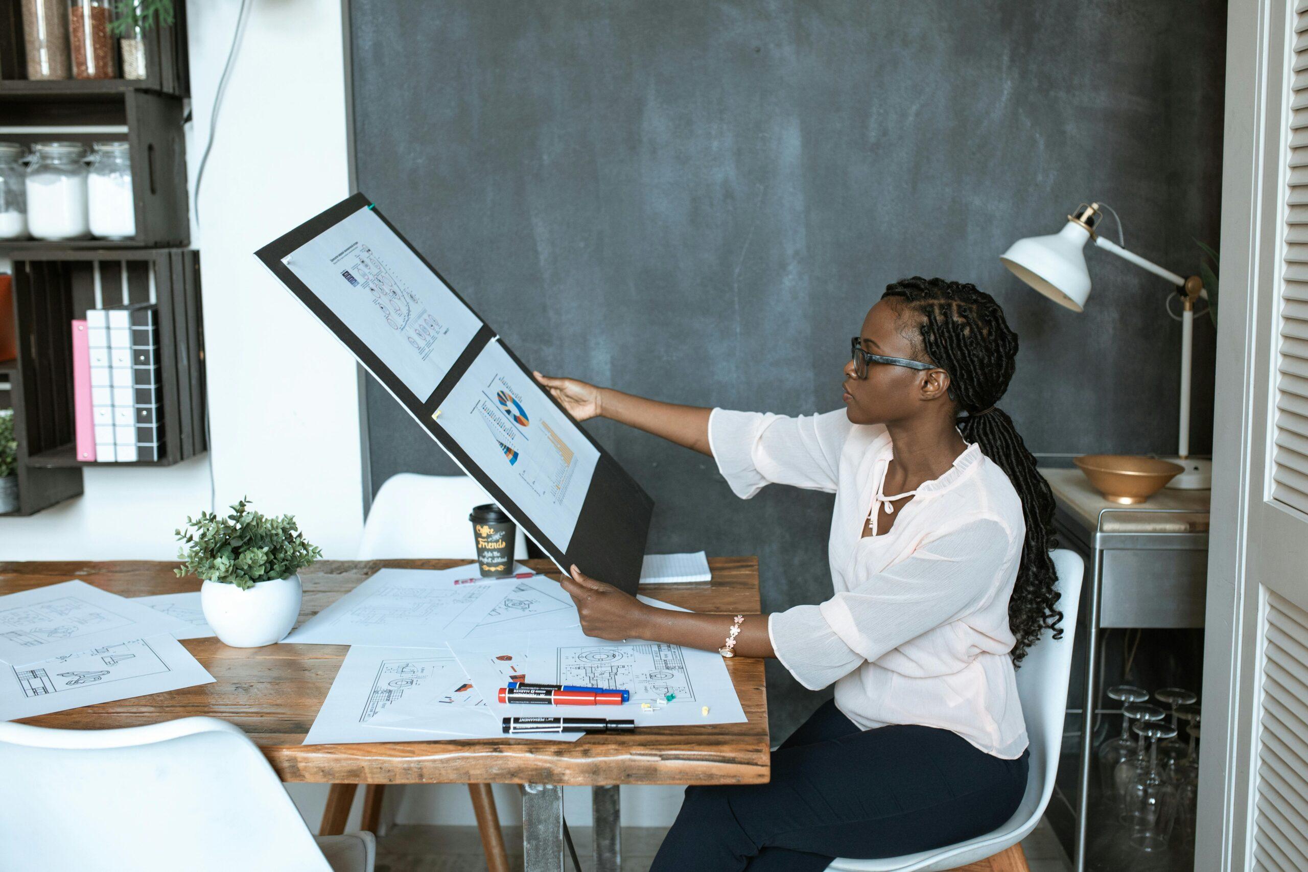 Creare presentazioni interattive con Canva. L'immagine mostra una professionista che lavora ad una presentazione nel proprio ufficio, seduta alla propria scrivania. 
